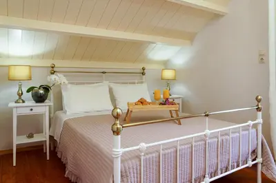 a bedroom with a white bed with a white bedspread at Arch Houses - Nature Escape with Shared Pool in Spiliá