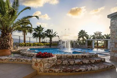 a swimming pool with a fountain in a resort at Epavlis Akrotiri in Chania Town