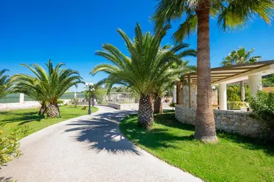 a pathway with palm trees and a building at Epavlis Akrotiri in Chania Town