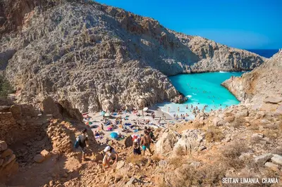 a group of people on a beach near the water at Epavlis Akrotiri in Chania Town