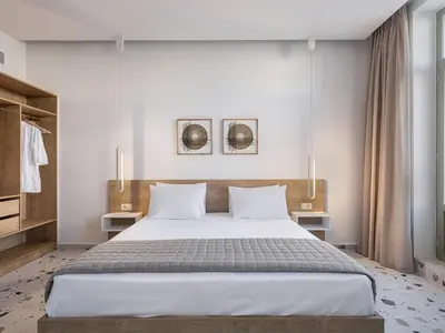 a bedroom with a large bed with white sheets and pillows at Cretan Berry Kondylaki in Chania Town