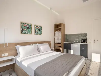 a bedroom with a large bed and a kitchen at Cretan Berry Kondylaki in Chania Town
