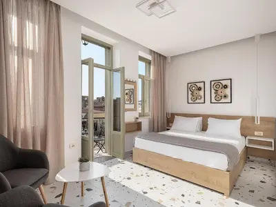 a bedroom with a bed and a couch and a chair at Cretan Berry Kondylaki in Chania Town