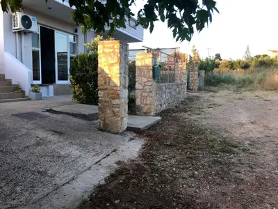 a group of stone pillars in front of a house at Livingfy Apt with mountain view & garden in Vamos