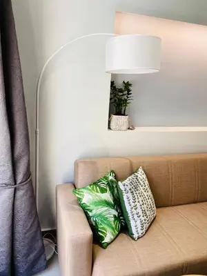 a couch with two pillows on it with a lamp at Ivy, 4 minutes from the sea in Chania Town