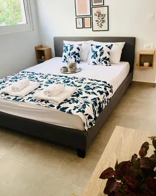 a bedroom with a bed with blue and white sheets at Ivy, 4 minutes from the sea in Chania Town