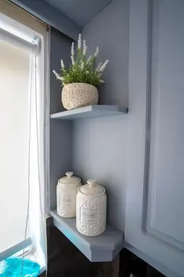 two white vases sitting on shelves next to a window at Eden’s garden in Chania Town