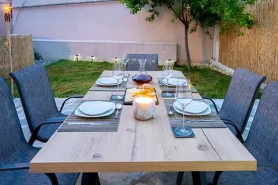 a wooden table with plates and wine glasses on it at Eden’s garden in Chania Town