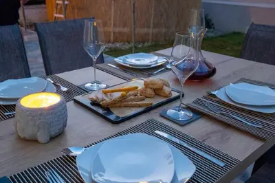 a wooden table with white plates and wine glasses at Eden’s garden in Chania Town