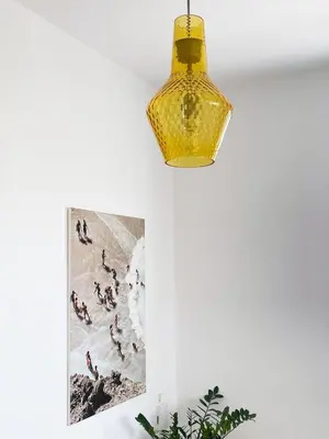 a yellow light hanging from a white wall with a picture at FLAT 45 in Kounoupidhianá