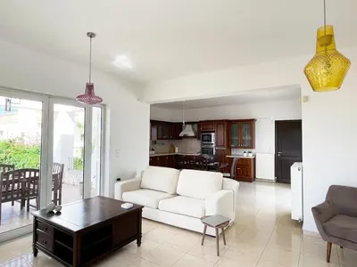 a living room with a white couch and a table at FLAT 45 in Kounoupidhianá