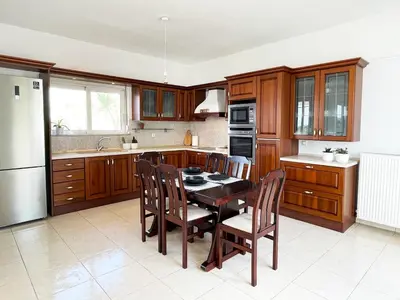 a kitchen with wooden cabinets and a table and chairs at FLAT 45 in Kounoupidhianá