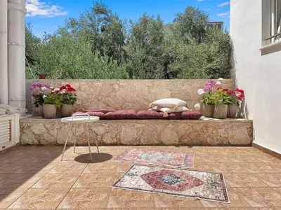 a bench with a pillow and a table and flowers at FLAT 45 in Kounoupidhianá