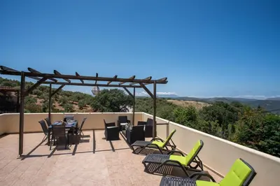a patio with chairs and a table with a view at Villa Festos in Voúvai
