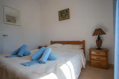 a bedroom with two beds with blue pillows on them at Villa Festos in Voúvai