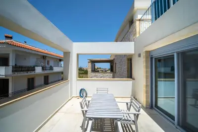 a table and chairs on the balcony of a building at Aiolos Executive Suite in Galatás