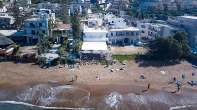 an aerial view of a beach with people on it at Queen Mary Beachfront Studios in Agia Marina Nea Kydonias