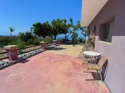 a patio with a table and chairs next to a building at Beautiful Life Rooms with Sea View - Next to Elafonisi Beach in Elafonisi