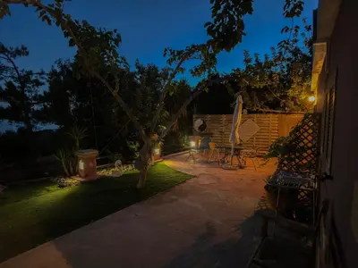a backyard with a table and a tree at night at Beautiful Life Rooms with Sea View - Next to Elafonisi Beach in Elafonisi