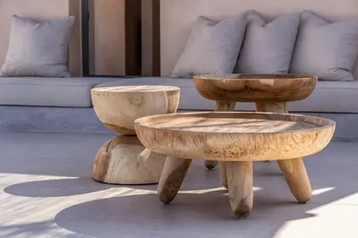 a pair of wooden ottomans sitting next to a couch at Kaliva Residence in Kalyves