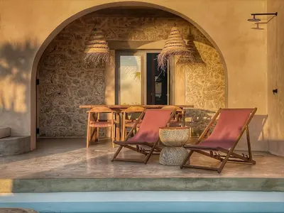 a patio with a table and chairs in an archway at Kaliva Residence in Kalyves