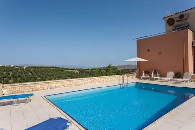 a swimming pool with a view of a villa at Hillside Seaview Apartment in Stalos