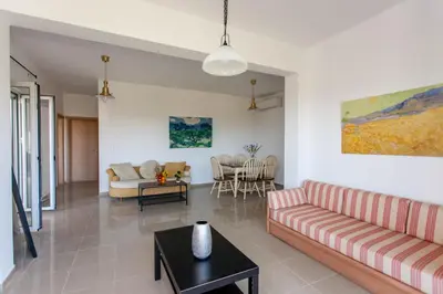 a living room with a couch and a table at Hillside Seaview Apartment in Stalos