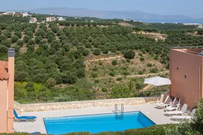 a villa with a swimming pool on a hill at Hillside Seaview Apartment in Stalos