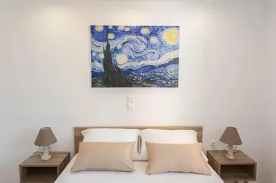a painting hanging above a bed with two night stands at Hillside Seaview Apartment in Stalos