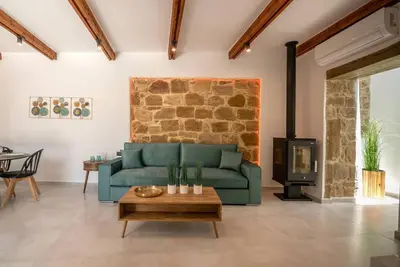 a living room with a green couch and a brick wall at White House Boutique in Koukounará