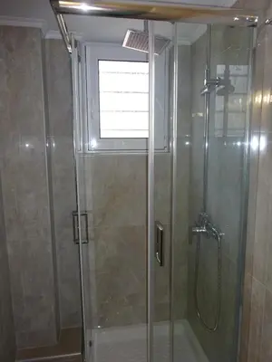 a shower with a glass door and a window at Virma Studio in Chania Town