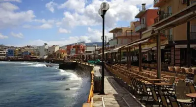 a row of tables and chairs next to the ocean at Virma Studio in Chania Town