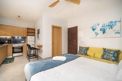 a bedroom with a large bed and a kitchen at Cozy Spot near the beach in Plataniás
