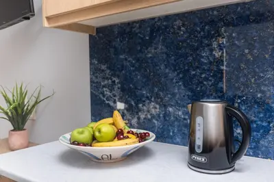 a bowl of fruit on a counter next to a coffee maker at Cozy Spot near the beach in Plataniás
