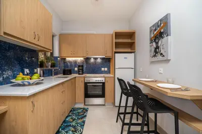 a kitchen with wooden cabinets and a table and chairs at Cozy Spot near the beach in Plataniás
