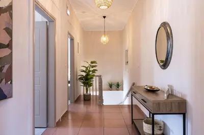 a hallway with a bathroom with a sink and a mirror at Strat's City Loft in Chania Town
