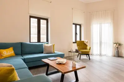 a living room with a blue couch and a table at Strat's City Loft in Chania Town