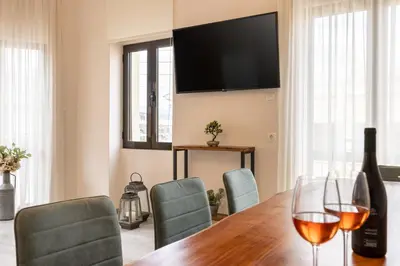 a dining room with a table with a bottle of wine at Strat's City Loft in Chania Town