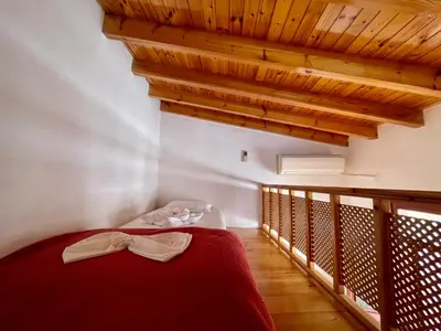 a bedroom with a red bed and wooden ceilings at Odyssey House in Chania Town