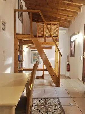 a loft bed in a room with a table at Odyssey House in Chania Town