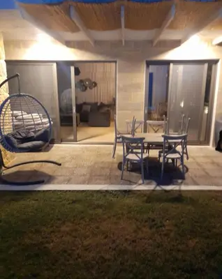 a patio with a table and chairs and a couch at Celeste Suite on the Beach in Agia Marina Nea Kydonias