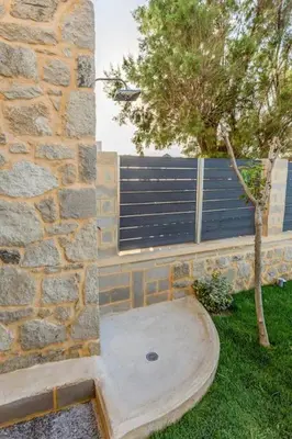 a stone wall with a tree and a window at Celeste Suite on the Beach in Agia Marina Nea Kydonias