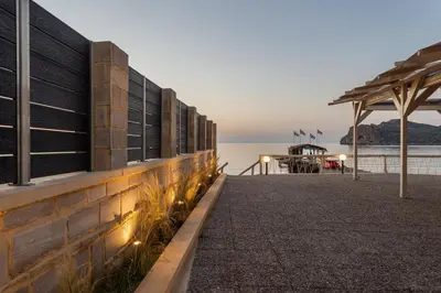 a walkway next to the water with a pier at Celeste Suite on the Beach in Agia Marina Nea Kydonias