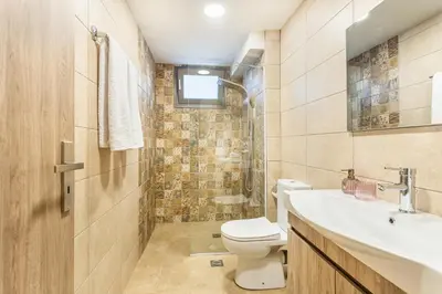 a bathroom with a toilet and a sink at Celeste Suite on the Beach in Agia Marina Nea Kydonias