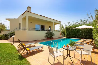 a villa with a swimming pool and a house at Villa Aggeliki by Villa Plus in Pírgos Psilonérou