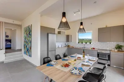 a kitchen and dining room with a table and chairs at Villa Aggeliki by Villa Plus in Pírgos Psilonérou