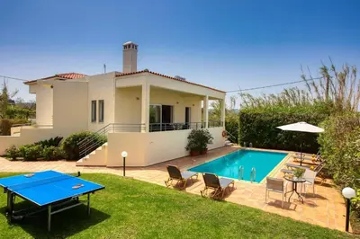a villa with a swimming pool and a house at Villa Aggeliki by Villa Plus in Pírgos Psilonérou