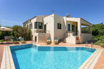a villa with a swimming pool in front of a house at Villa Anni by Villa Plus in Pírgos Psilonérou