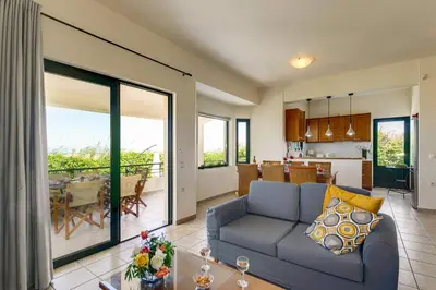 a living room with a couch and a dining room at Villa Anni by Villa Plus in Pírgos Psilonérou