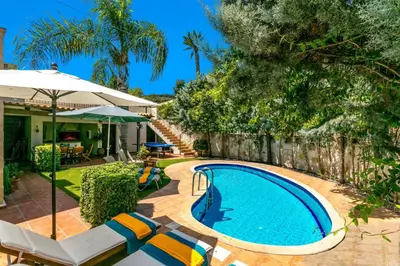 a swimming pool in a yard with chairs and an umbrella at Villa Areti by Villa Plus in Spiliá